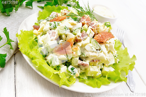 Image of Salad of salmon and avocado with mayonnaise on white wooden boar