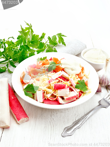 Image of Salad of surimi and tomatoes on light wooden table