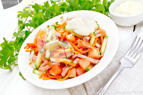 Image of Salad of sausage and spicy carrots on light wooden board