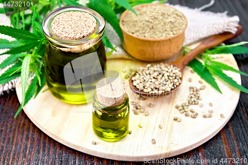 Image of Oil hemp in two jars with flour on dark board