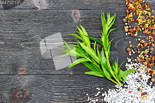 Image of Tarragon leaves with spices on black wooden board