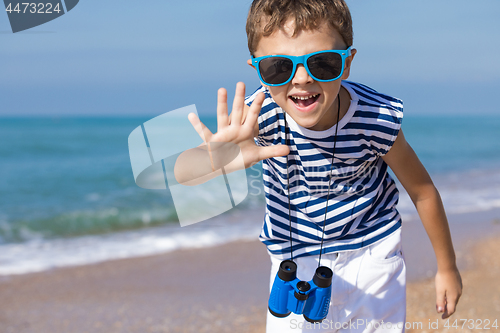 Image of One happy little boy playing on the beach at the day time.