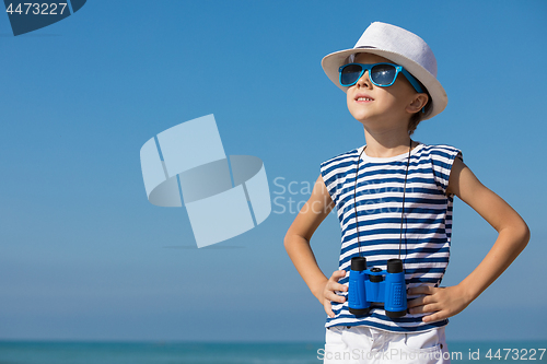 Image of One happy little boy playing on the beach at the day time.