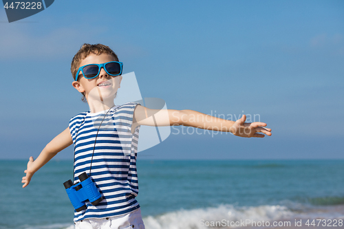 Image of One happy little boy playing on the beach at the day time.