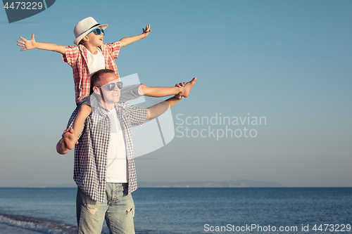 Image of Father and son playing on the beach at the day time.