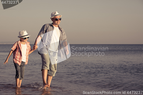 Image of Father and son playing on the beach at the day time.