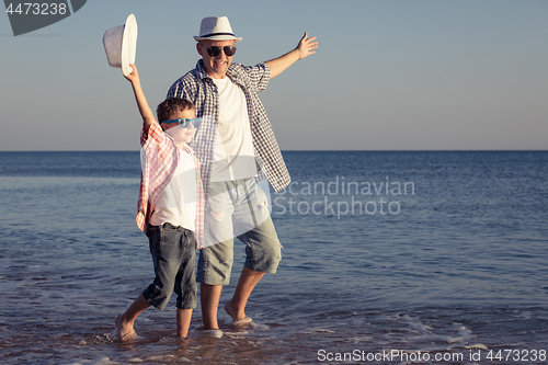 Image of Father and son playing on the beach at the day time.