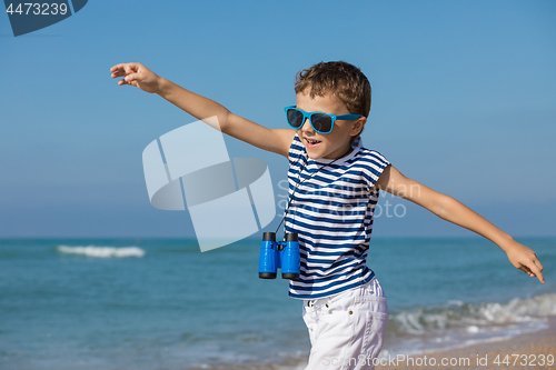 Image of One happy little boy playing on the beach at the day time.