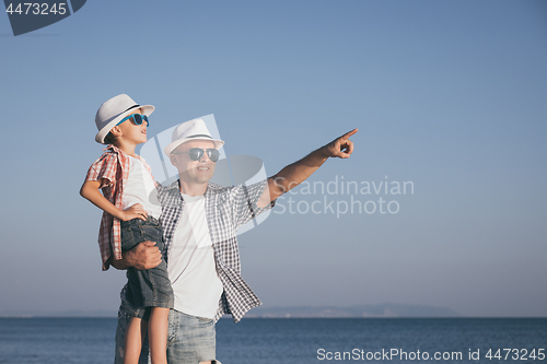 Image of Father and son playing on the beach at the day time.