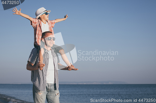 Image of Father and son playing on the beach at the day time.