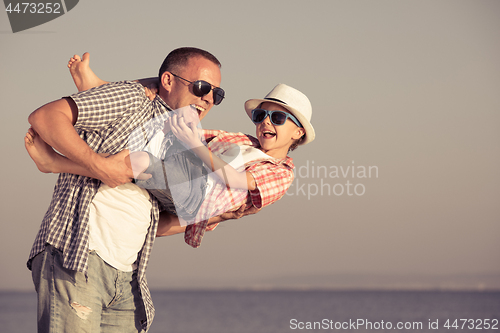 Image of Father and son playing on the beach at the day time.