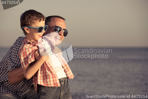 Image of Father and son playing on the beach at the day time.