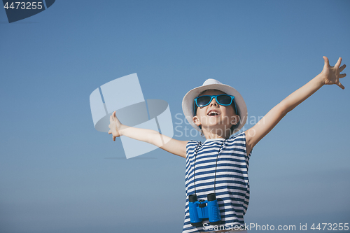 Image of One happy little boy playing on the beach at the day time. 