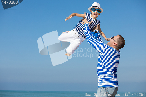 Image of Father and son playing on the beach at the day time. 