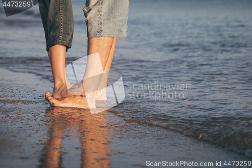 Image of Father and son playing on the beach at the day time.