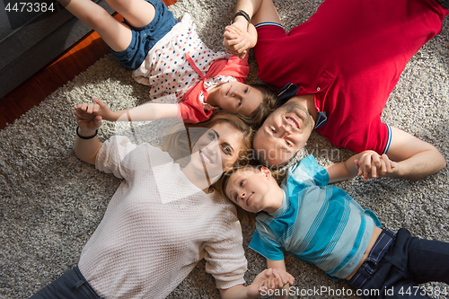 Image of happy family lying on the floor