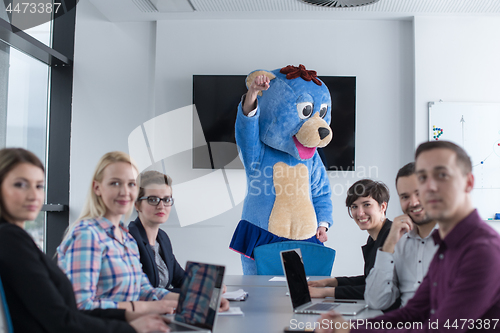 Image of boss dresed as bear having fun with business people in trendy of