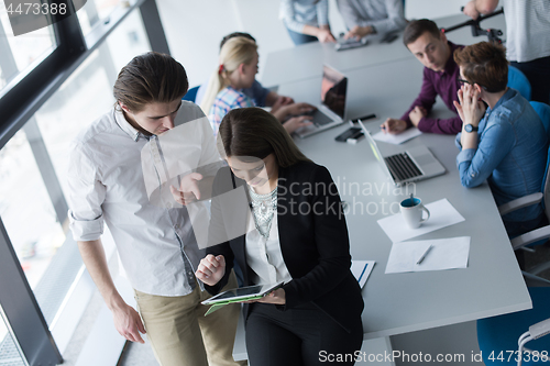 Image of Two Business People Working With Tablet in office