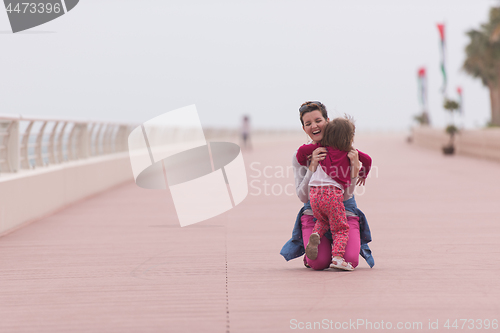 Image of mother and cute little girl on the promenade by the sea