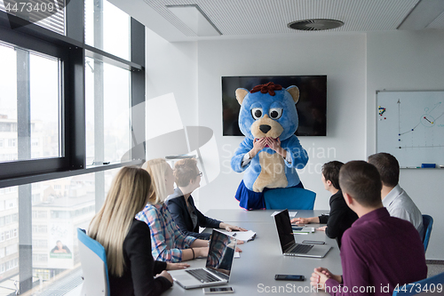 Image of boss dresed as bear having fun with business people in trendy of