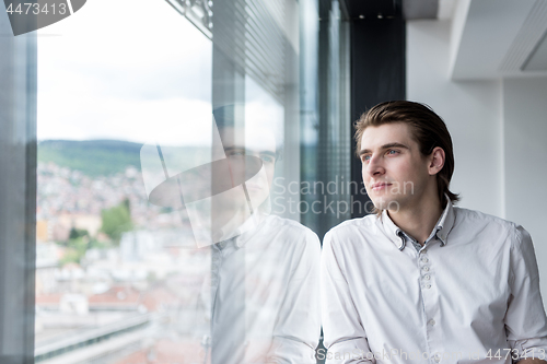 Image of young businessman in startup office by the window