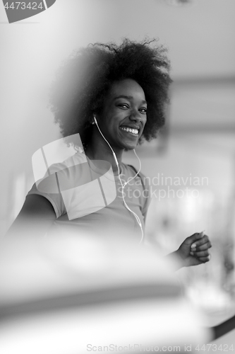 Image of afro american woman running on a treadmill