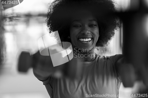 Image of woman working out in a crossfit gym with dumbbells