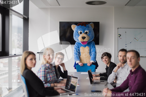 Image of boss dresed as bear having fun with business people in trendy of