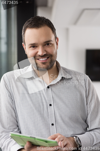 Image of Businessman Using Tablet In Office Building by window