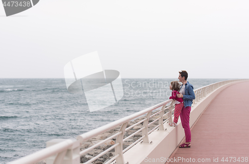 Image of mother and cute little girl on the promenade by the sea