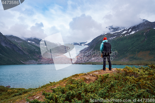 Image of Girl tourist looks at a glacier. Svartisen Glacier in Norway.