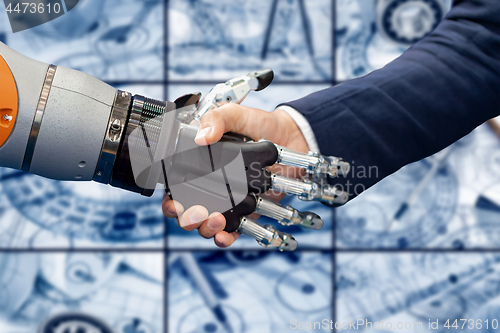 Image of Hand of a businessman shaking hands with a Android robot.