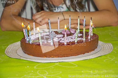 Image of Young girl is to blow out candles on her birthday cake