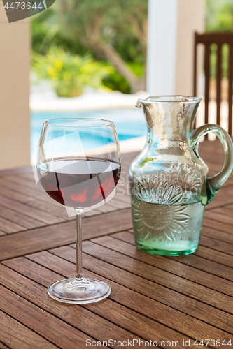 Image of Glass of red wine in poolside