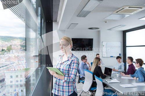 Image of Pretty Businesswoman Using Tablet In Office Building by window