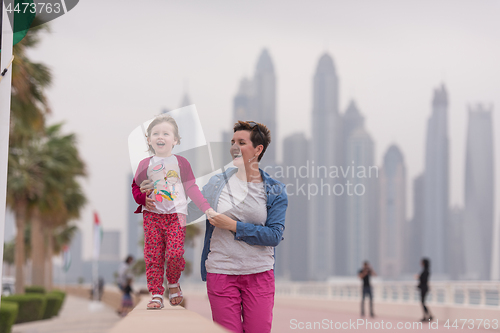Image of mother and cute little girl on the promenade