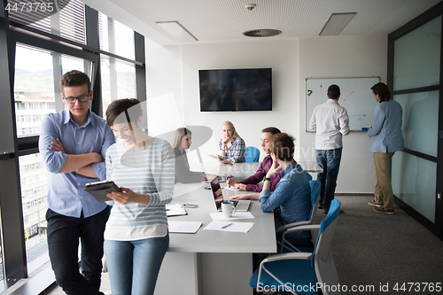 Image of Two Business People Working With Tablet in office