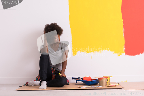 Image of back female painter sitting on floor