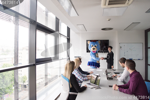 Image of boss dresed as bear having fun with business people in trendy of