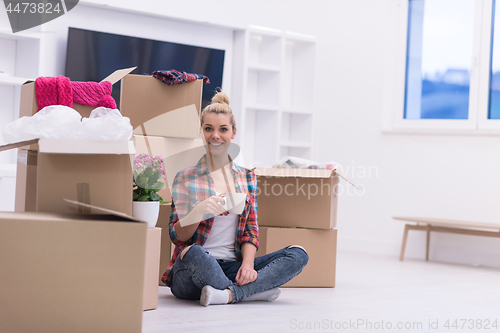 Image of woman with many cardboard boxes sitting on floor