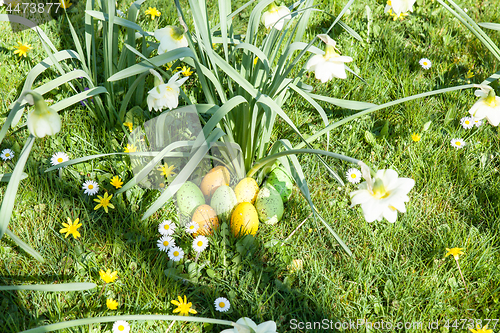 Image of colored Easter eggs hidden in flowers and grass