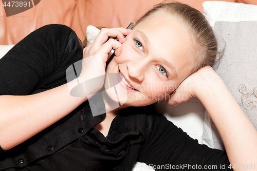 Image of girl on the phone lying on a sofa