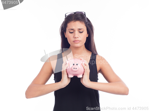 Image of Young woman worried with a piggy bank