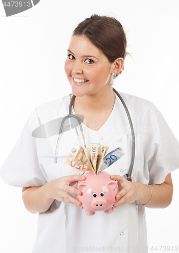 Image of happy woman doctor with piggy bank full of money