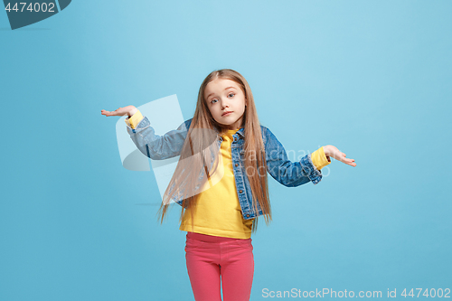 Image of Beautiful teen girl looking suprised and bewildered isolated on blue