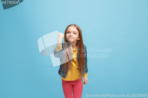 Image of Portrait of angry teen girl on a blue studio background