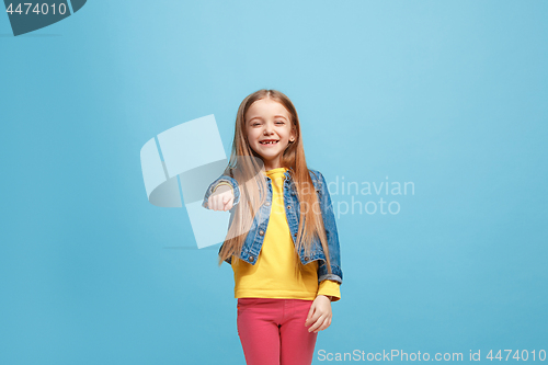 Image of The happy teen girl pointing to you, half length closeup portrait on blue background.