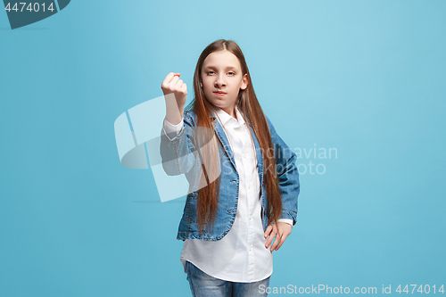 Image of Portrait of angry teen girl on a blue studio background