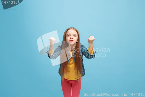 Image of Portrait of angry teen girl on a blue studio background