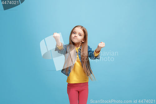 Image of Portrait of angry teen girl on a blue studio background